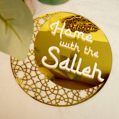 A gold circular hanging ornament with a crescent moon design and the text 'Home with the Salleh' on it.