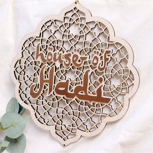 A decorative wooden and acrylic ornament with geometric patterns and the text n a boho style setting.
